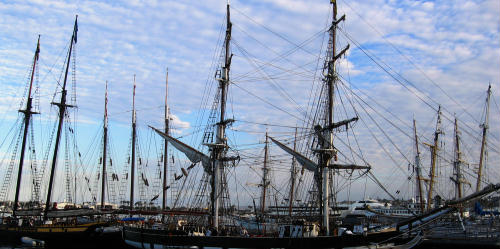 dark masts in a colorful sky