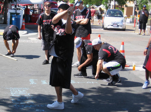 stickball player prepares while lineup is written