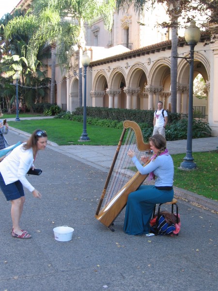 Lady plays harp on El Prado in Balboa Park.