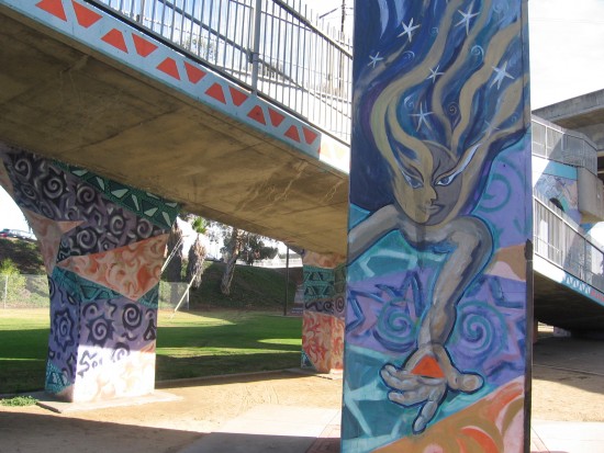 Small mural near pedestrian walkway that crosses freeway.