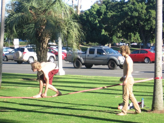 Two young men enjoy slacklining in Balboa Park.