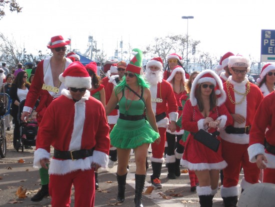 A mob of Santas and one green elf.
