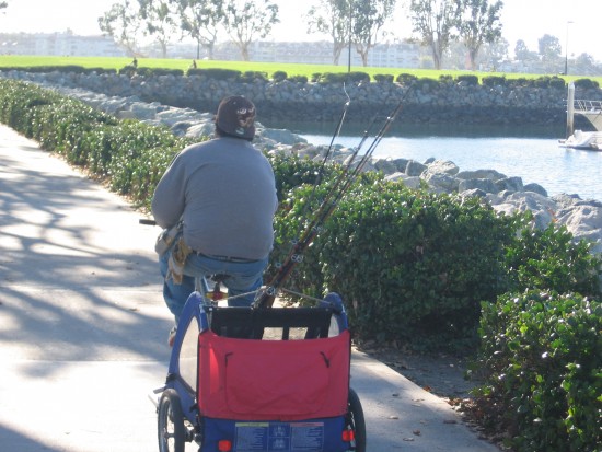Heading to the pier with a bunch of fishing rods.