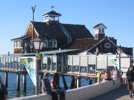 People sit on wall near the Pier Cafe.