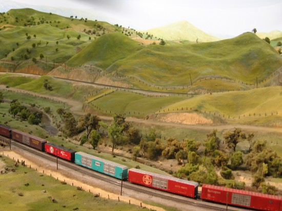 HO Scale model train travels through Tehachapi Pass exhibit.