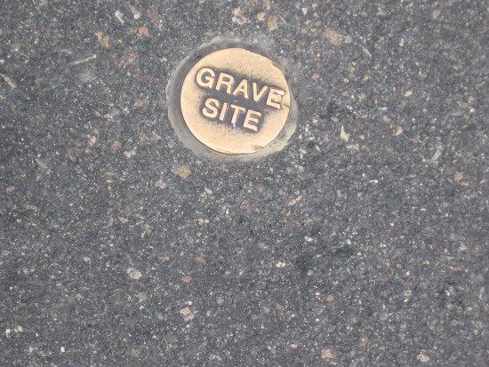 Grave site marker embedded in San Diego Avenue asphalt.