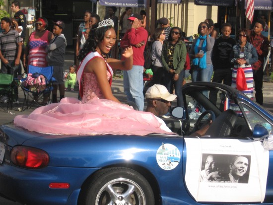 A beautiful parade queen waves to the large crowd.