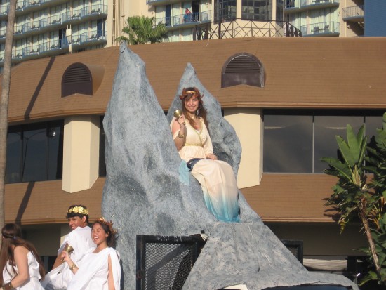 A smiling beauty perched high atop a parade float.