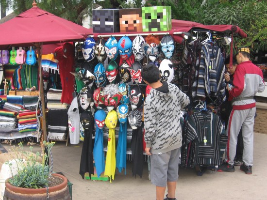 Kid checks out a bunch of Mexican Lucha Libre masks.