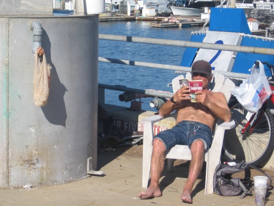 Man reads book on Tuna Harbor Pier on New Year's Day.