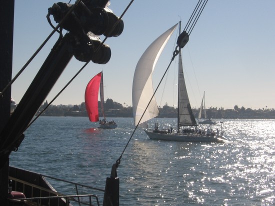 Sailboats pass live bait fishing boat docked at Tuna Harbor Pier.