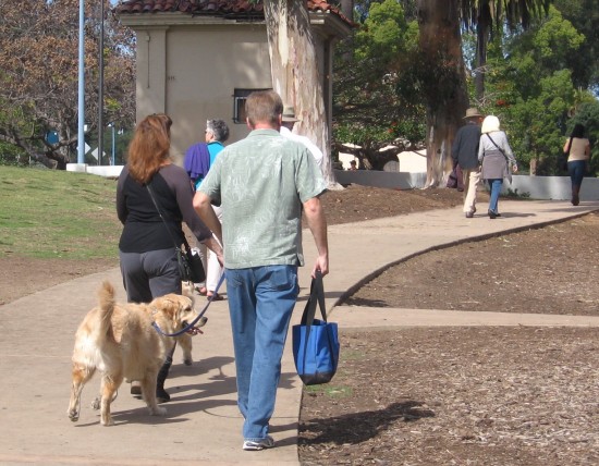 Dogs and humans head toward Bark in Balboa Park.