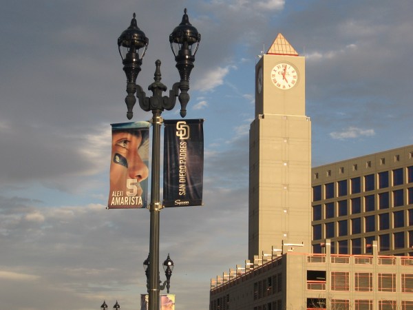 Imperial Transit Station clock tower and Padres banner under clouds.