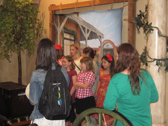 Girls pose for a picture in front of a western scene.