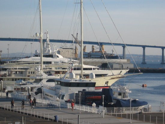 Luxury yachts with Coronado Bay Bridge in background.