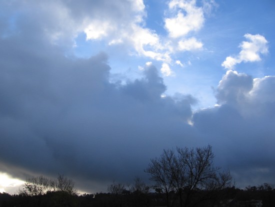Morning light emerges from behind a bank of clouds.