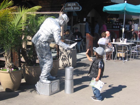 Silver robotic mime and a frozen high five.