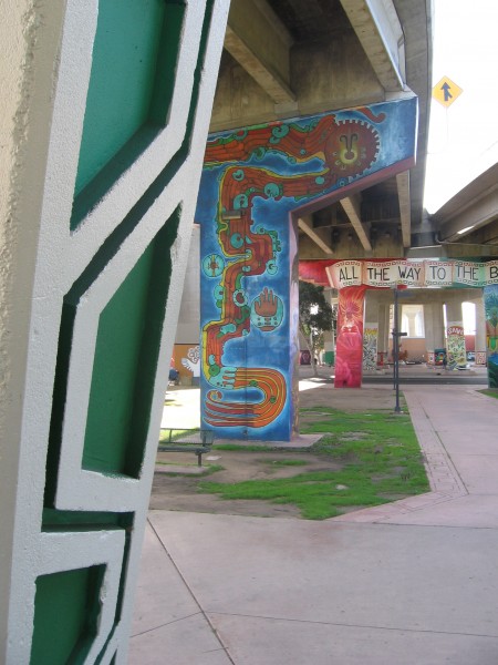 A series of murals on pillars supporting traffic lanes.