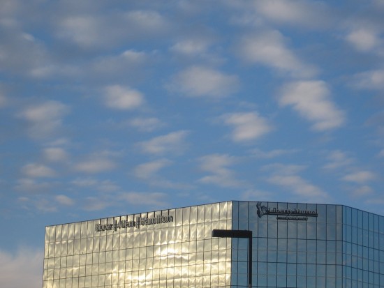 Gauzy clouds above a silver building.