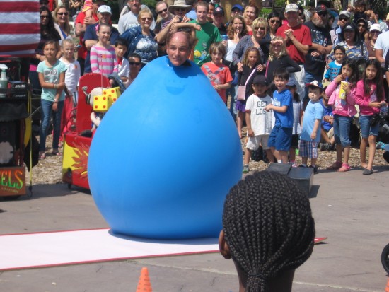 Skip Banks' head pops out of big balloon at Busker Festival.