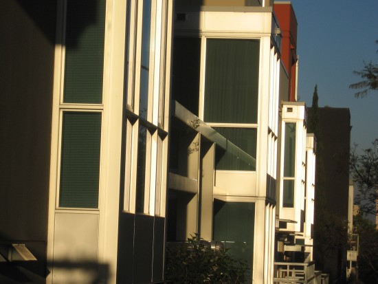 Slanting sunshine on building highlights layered geometry.