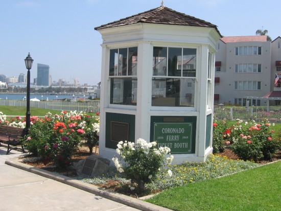 Old Coronado ferry ticket booth surrounded by flowers.
