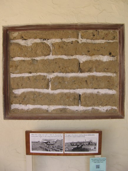 Gap in Lodge's stucco shows original adobe bricks.