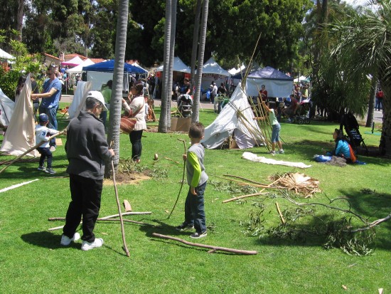 Kids learn how to set up teepees on a Balboa Park grassy area.
