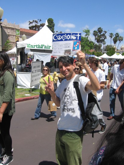 Peace sign and coexist sign in the crowd.