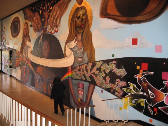 San Diego Museum of Art visitor walks past large indoor mural.
