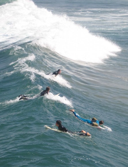 Surfers wait for the perfect wave near Imperial Beach pier.