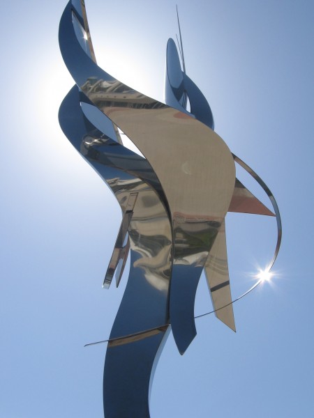 Sunlight glow behind silvery work of art.