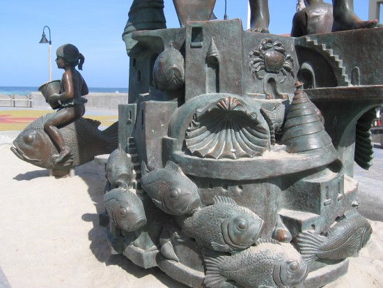 Crabs, shells, fish, sandcastle and girl with a pail.