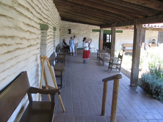 Walking along the outdoor corridor of old Spanish Colonial home.