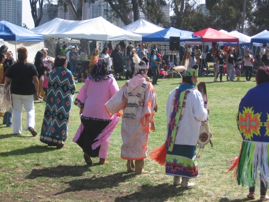 Mothers in native costume in a large round dance.