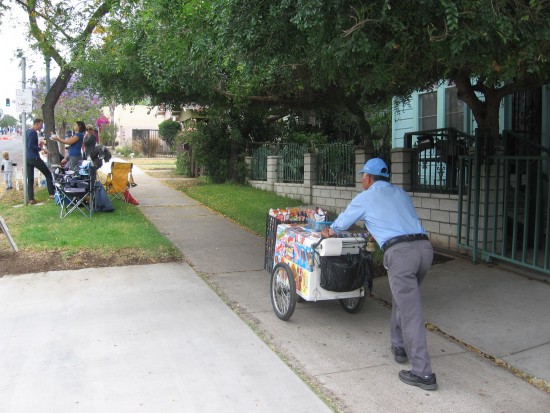 Man pushes Ice cream cart up 25th Street hill.