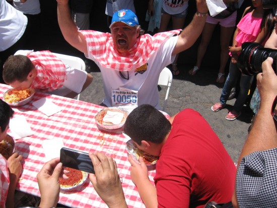 The sauce-faced winner raises his arms in triumph!