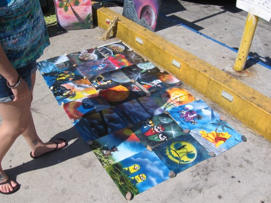 Someone checks out space art on the sidewalk.