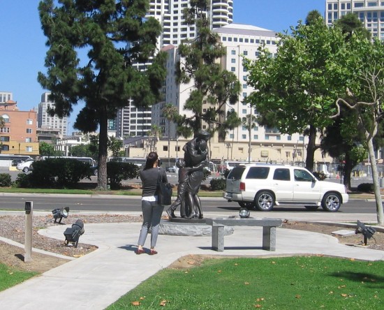 Woman photographs Homecoming sculpture.