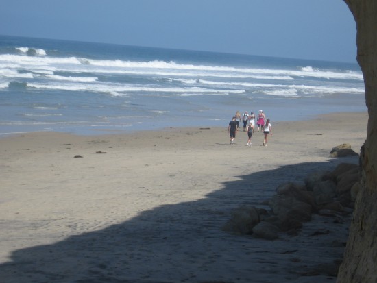 People walk north along Torrey Pines State Beach.