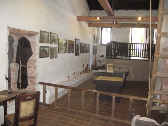 Padres' living quarters with adobe walls and wooden beams.