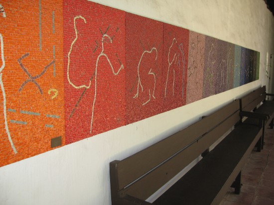 Modern abstract mural lines wall above wood bench.