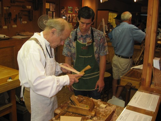 Master woodworker demonstrates planing skills.