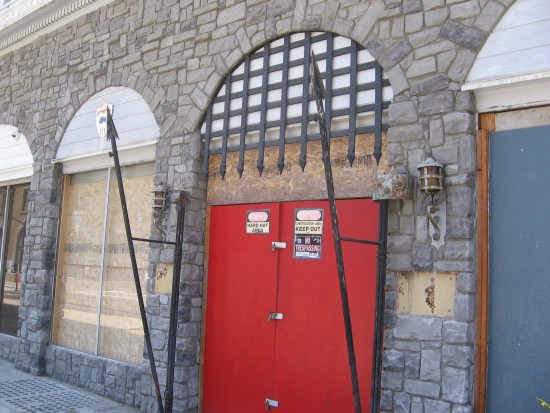 Old door with spears and portcullis is locked shut.