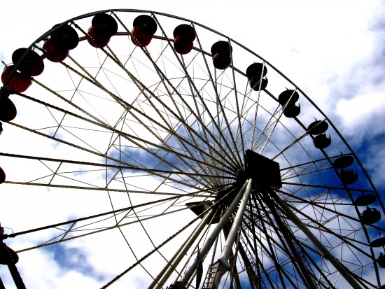 The giant Ferris wheel turns in the summer sky.