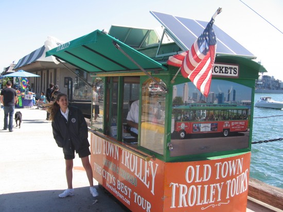 Old Town Trolley Tours booth has a flag out.