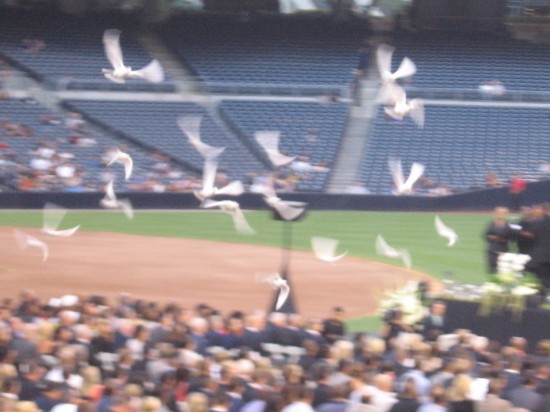White doves are released near the stage as program begins.