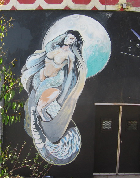 Snake-entwined female in front of moon.