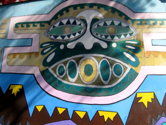 Stylized face watches from Centro Cultural de la Raza.