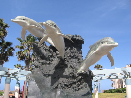 Ocean Riders bronze sculpture by Wyland has three dolphins.